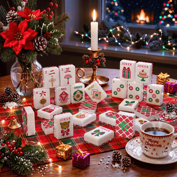A styled holiday tabletop scene with many white mahjong-style tiles featuring Christmas-themed designs such as red plaid, green and red icons, and words like JOKER. A lit candle, pinecones, a red poinsettia arrangement, a mug reading Merry Christmas, and a cozy window with warm lights are visible in the background.