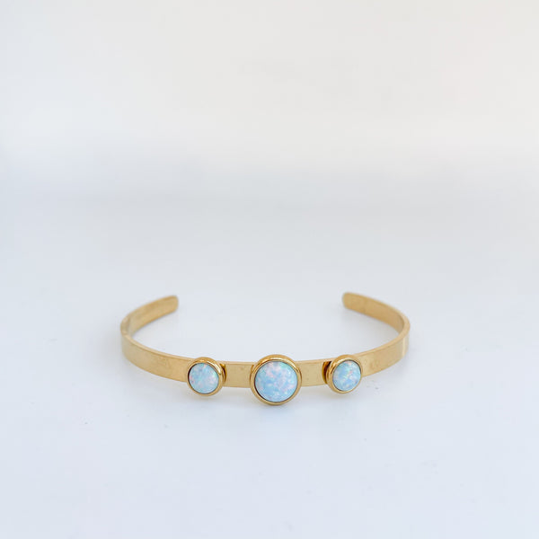 Gold headband with three opal stones on a light gray background
