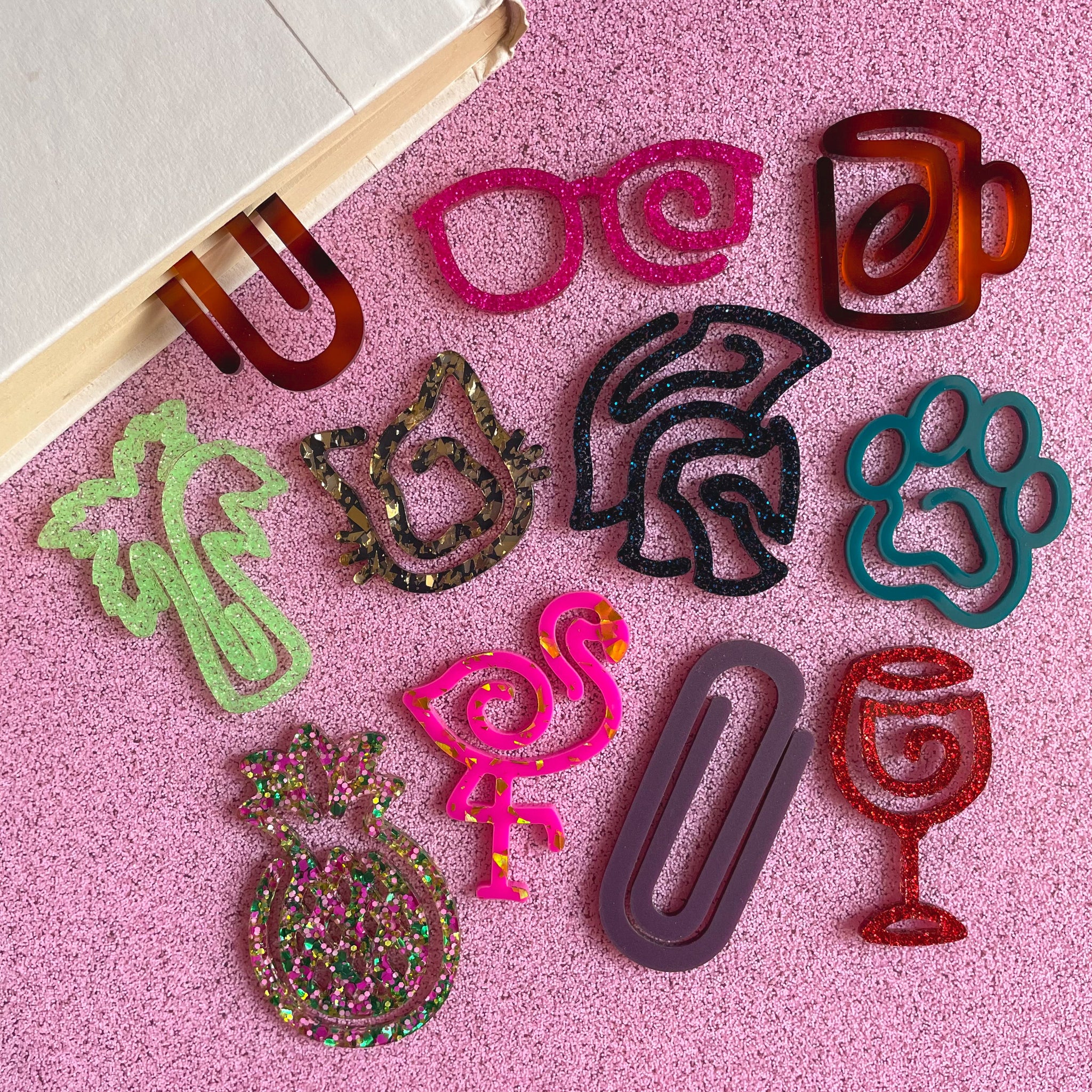 Colorful bookmarks shaped like various items on a pink surface