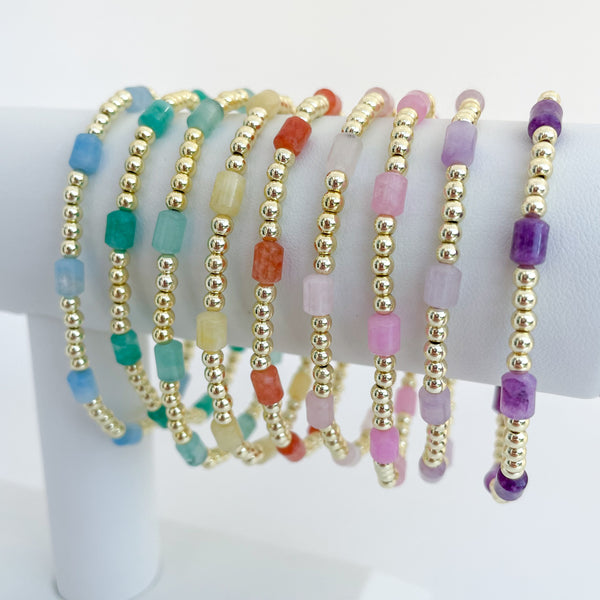 Set of rainbow colored beaded dyed jade bracelets on a bracelet bar