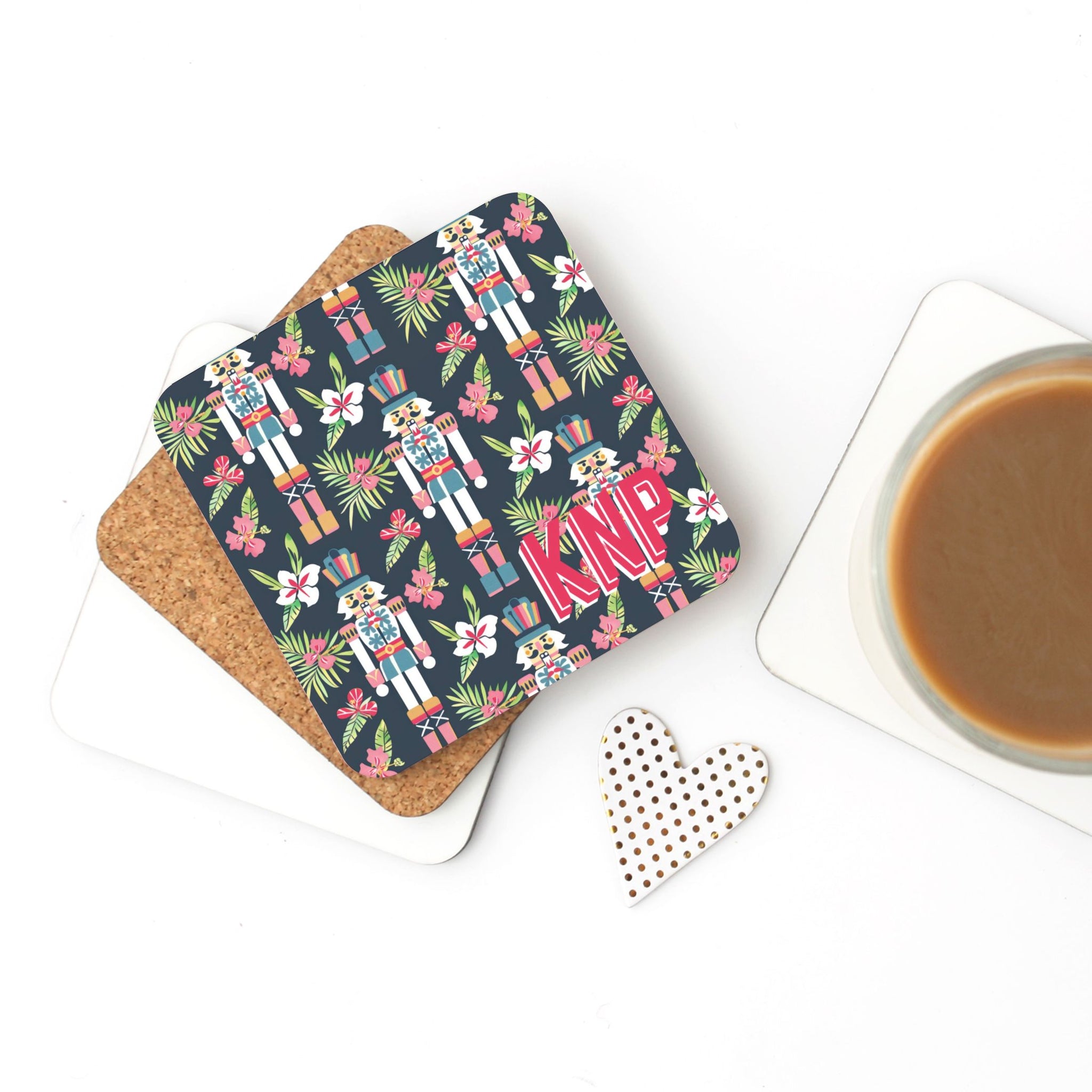 Coaster with nutcracker design and 'KNP' text on a white surface with a cup of coffee.