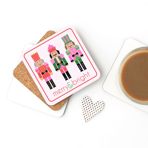 Coaster with nutcracker design and 'merry & bright' text on a white surface with a cup of coffee.