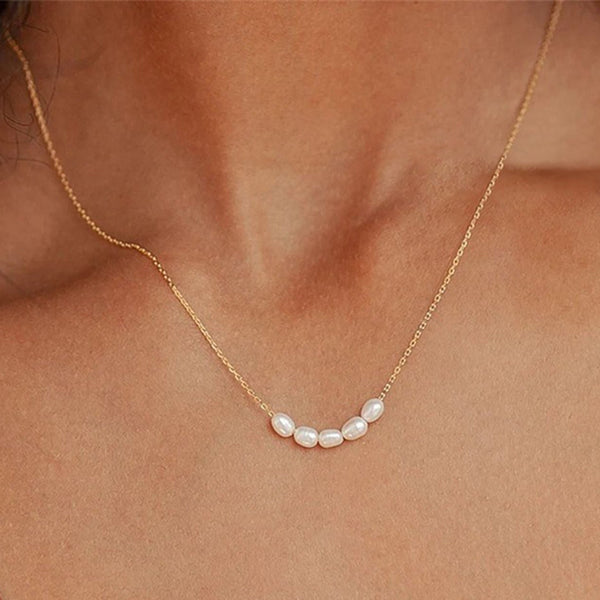 Gold necklace with pearls shown on a person's neck