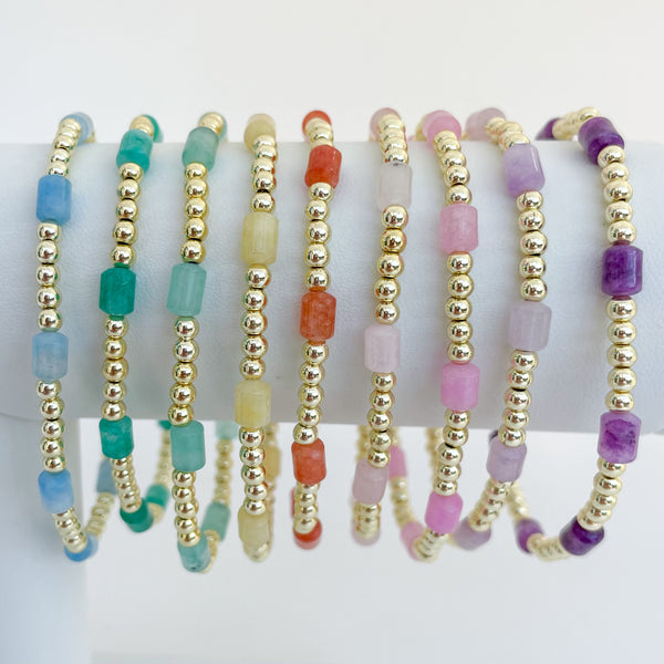 Set of rainbow colored beaded dyed jade bracelets on a bracelet bar