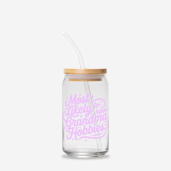 Glass tumbler with straw and wooden lid featuring pink text that says Most Likely to have Grandma Hobbies on a white background