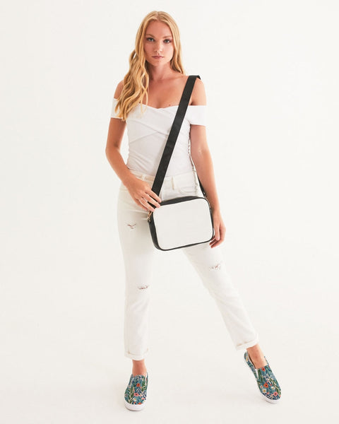 Woman holding a black and white crossbody bag against a white background