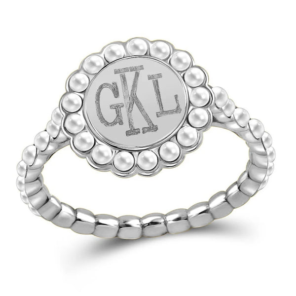 A silver signet ring featuring a circular face with the engraved initials 'GKL' and a border of small pearl-like beads, set on a beaded band, shown on a white background.