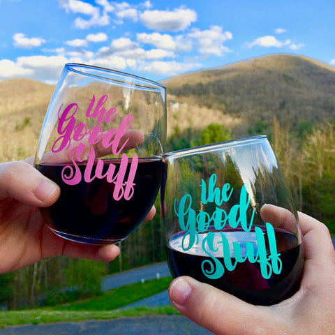 The Good Stuff stemless wine glass in front of the mountains and blue sky